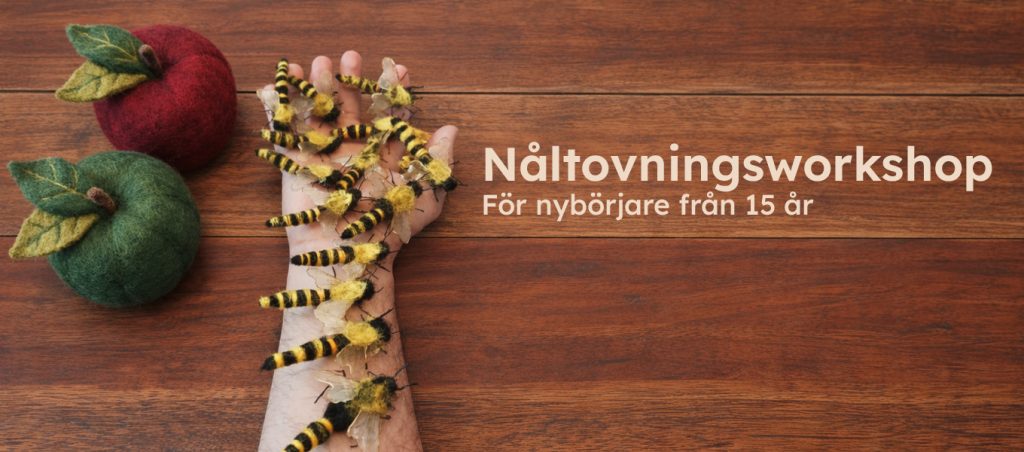 Färgfotografi. En hand ligger på ett träbord täckt av små nåltovade bin. Bredvid handen ligger två nåltovade äpplen i rött och grönt. Till höger står texten: ”Nåltovningsworkshop. För nybörjare från 15 år.”